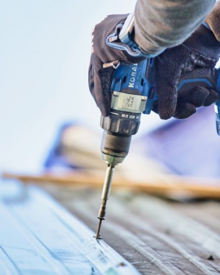 a person using a drill to drill a piece of wood