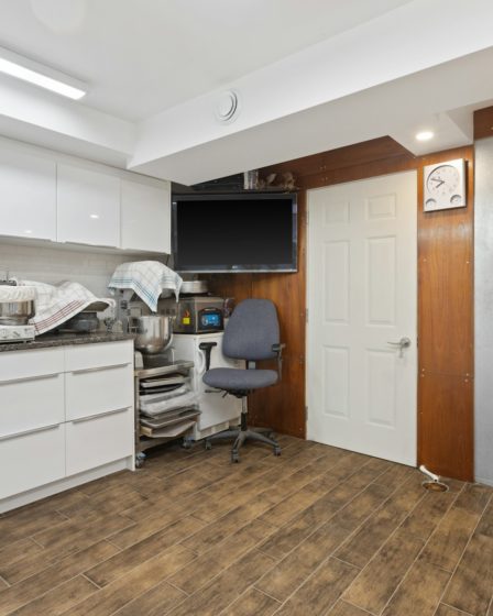 a room with a desk, chair and a television