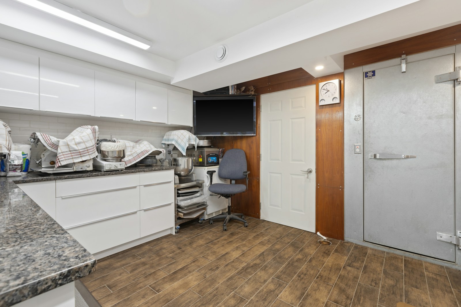 a room with a desk, chair and a television